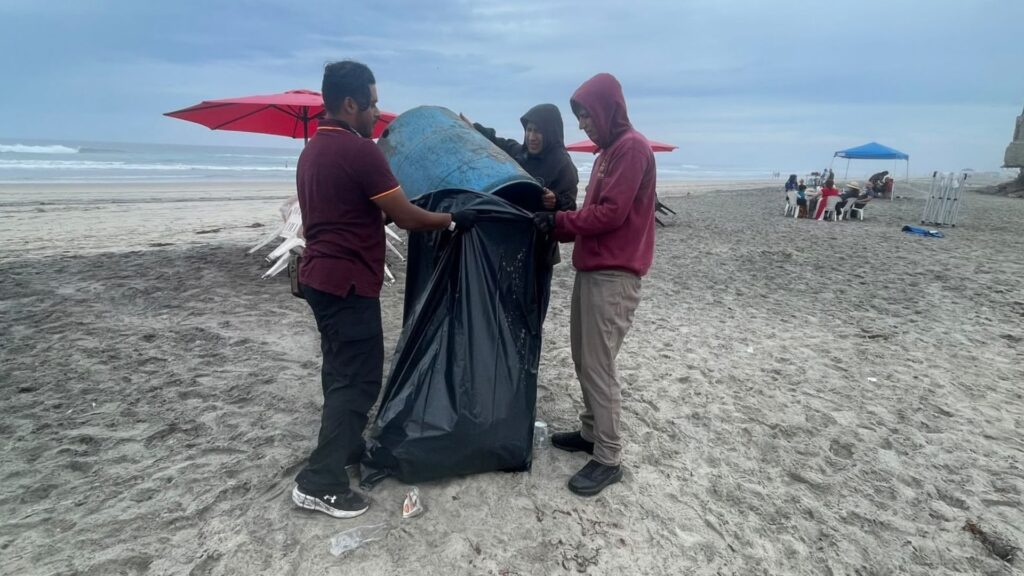 Personal de ZOFEMAT recolectando residuos en la orilla del mar durante la jornada de mantenimiento.