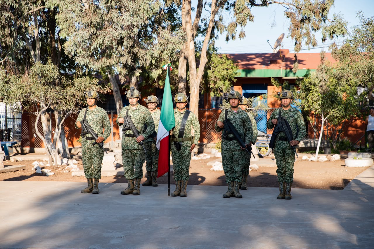 Elementos militares y estudiantes participan en la ceremonia cívica.